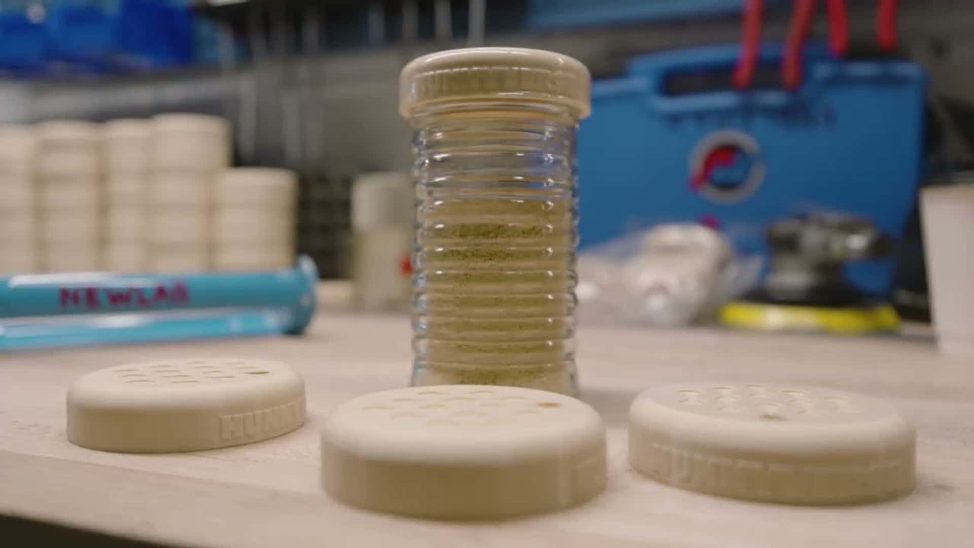 Nærbillede af komponenter til elbilbatterifremstilling på et arbejdsbord i et værksted.