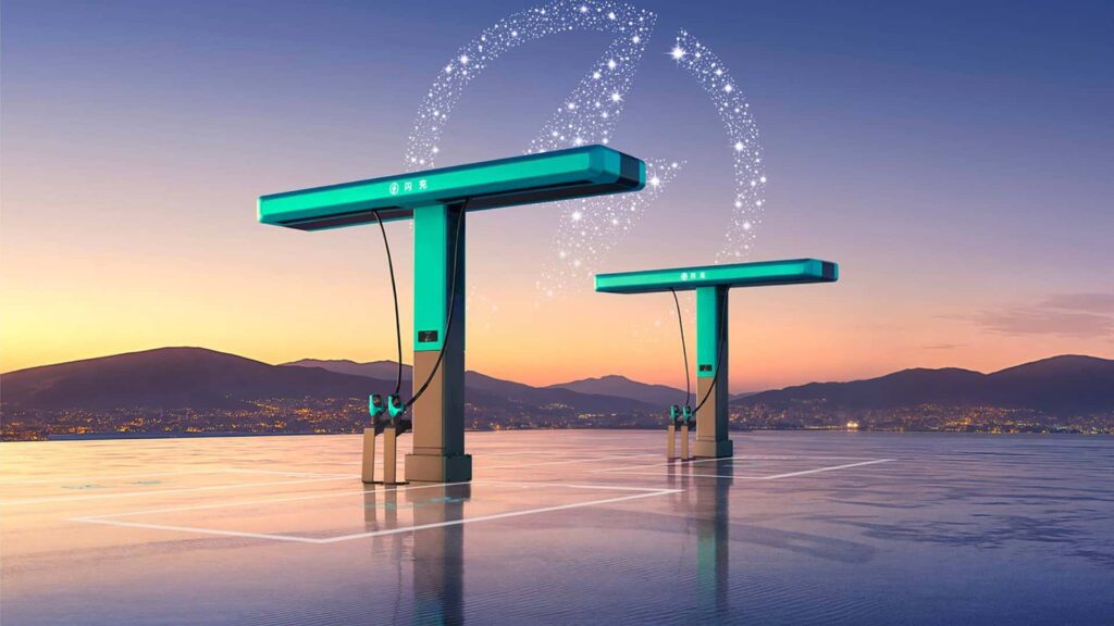 Elektriske ladestationer ved solnedgang med bylandskab i baggrunden