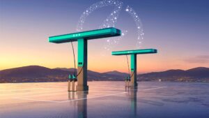 Elektriske ladestationer ved solnedgang med bylandskab i baggrunden