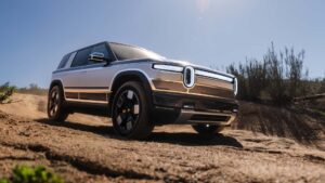Elektrisk SUV kører på en solrig dag i et øde terræn