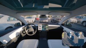Indvendig udsigt af Tesla Model 3 med autoparkeringsfunktion vist på skærmen, omgivet af parkerede biler