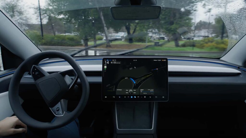 Tesla-bil med autopilot-funktion viser digitalt instrumentbræt og regnfuldt vejlandskab