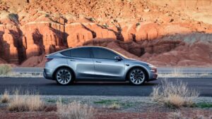 Sølv Tesla elbil foran røde klippeformationer