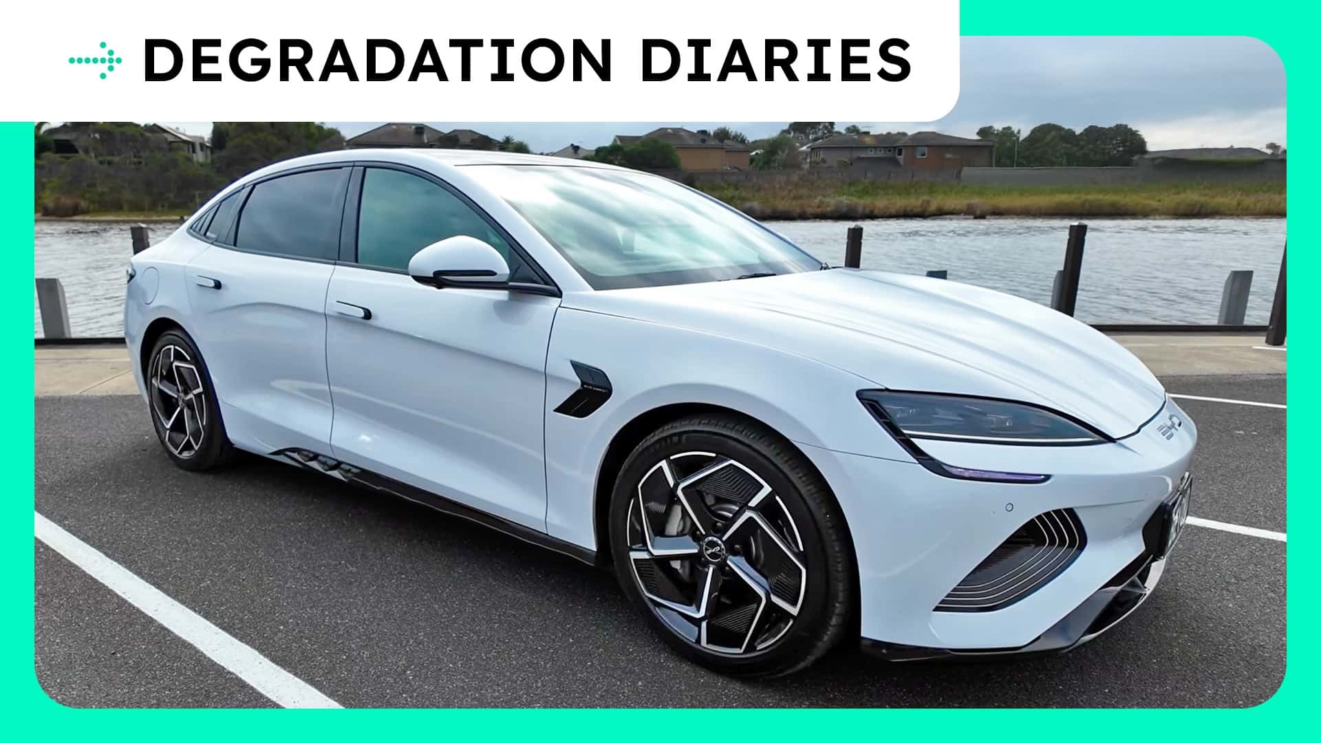 Hvid elbil parkeret ved en havn under overskriften 'Degradation Diaries'.