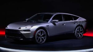 Ny Tesla model i sølvgrå farve på udstilling, fremhæver avanceret aerodynamisk design og slanke linjer