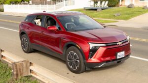 Chevrolet logo på rød elektrisk SUV med hund i vinduet