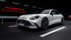 Hvid Mercedes-AMG GT 4-dørs coupé i en mørk tunnel med rødt skilt i baggrunden