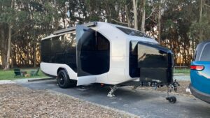 Moderne campingvogn designet til elektriske biler i skovmiljø