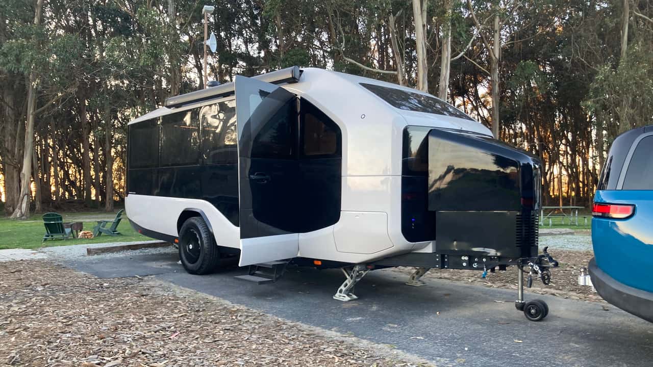 Moderne campingvogn designet til elektriske biler i skovmiljø