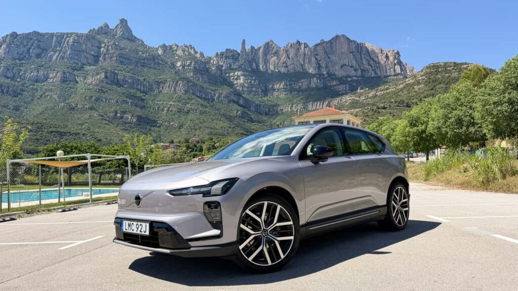 Elektrisk SUV foran maleriske bjerge og blå himmel