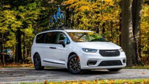 Chrysler minivan parkeret i skoven med cykel på taget