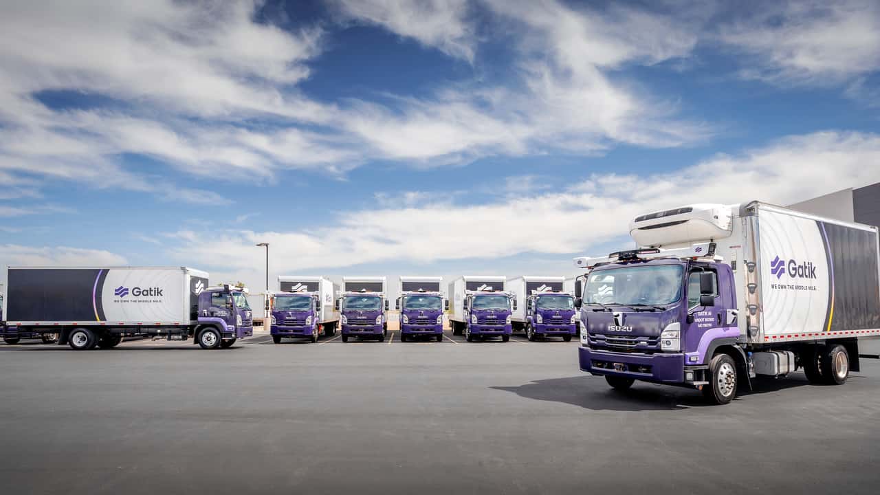 Isuzu lastbiler med Gatik logo på parkeringsplads