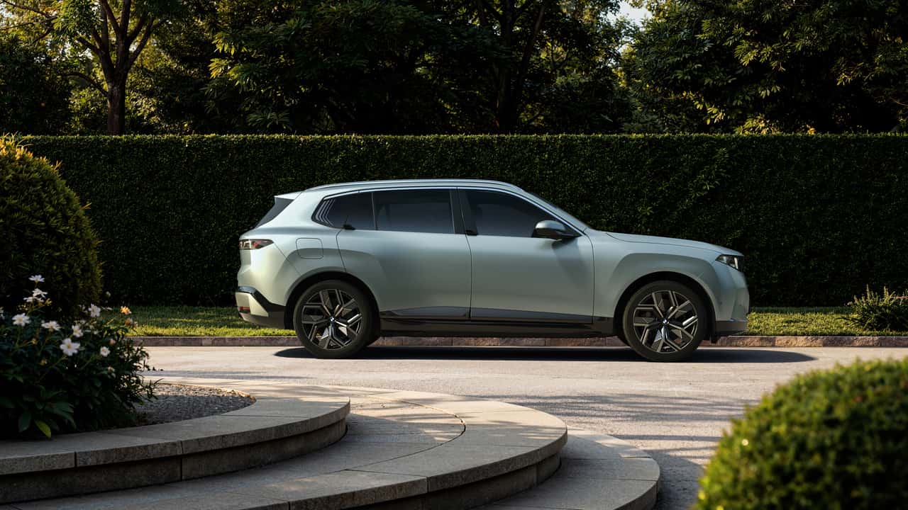 Kompakt elektrisk SUV parkeret ved en hæk