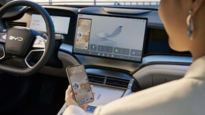 BYD bilinteriør med stor infotainmentskærm og smartphone