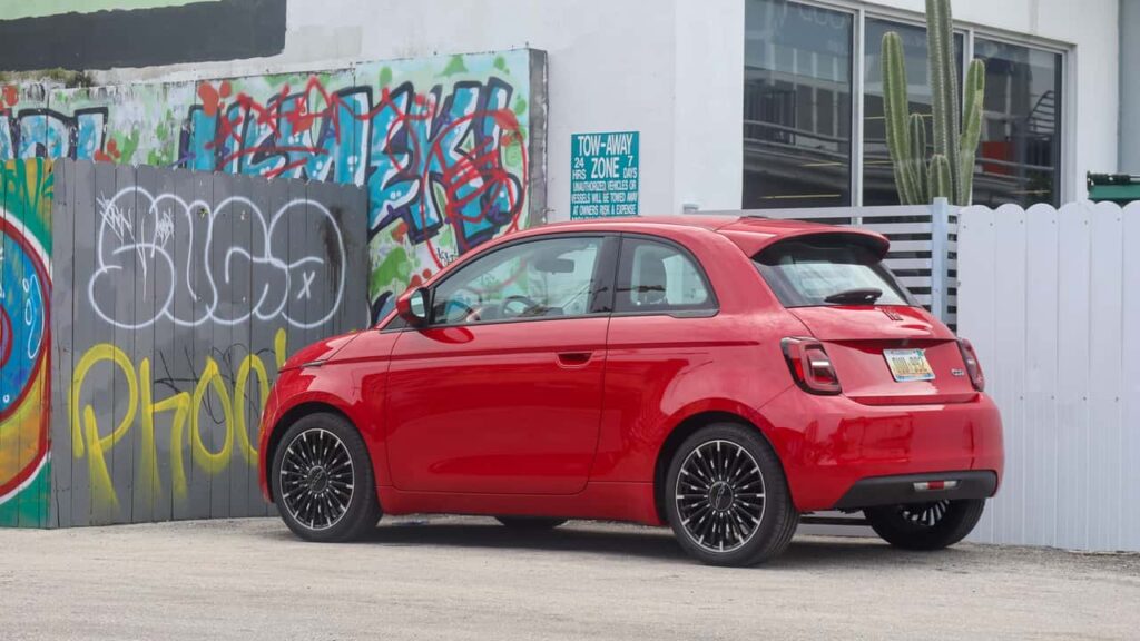 Rød Fiat 500e parkeret foran graffitimur