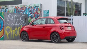 Rød Fiat 500e parkeret foran graffitimur