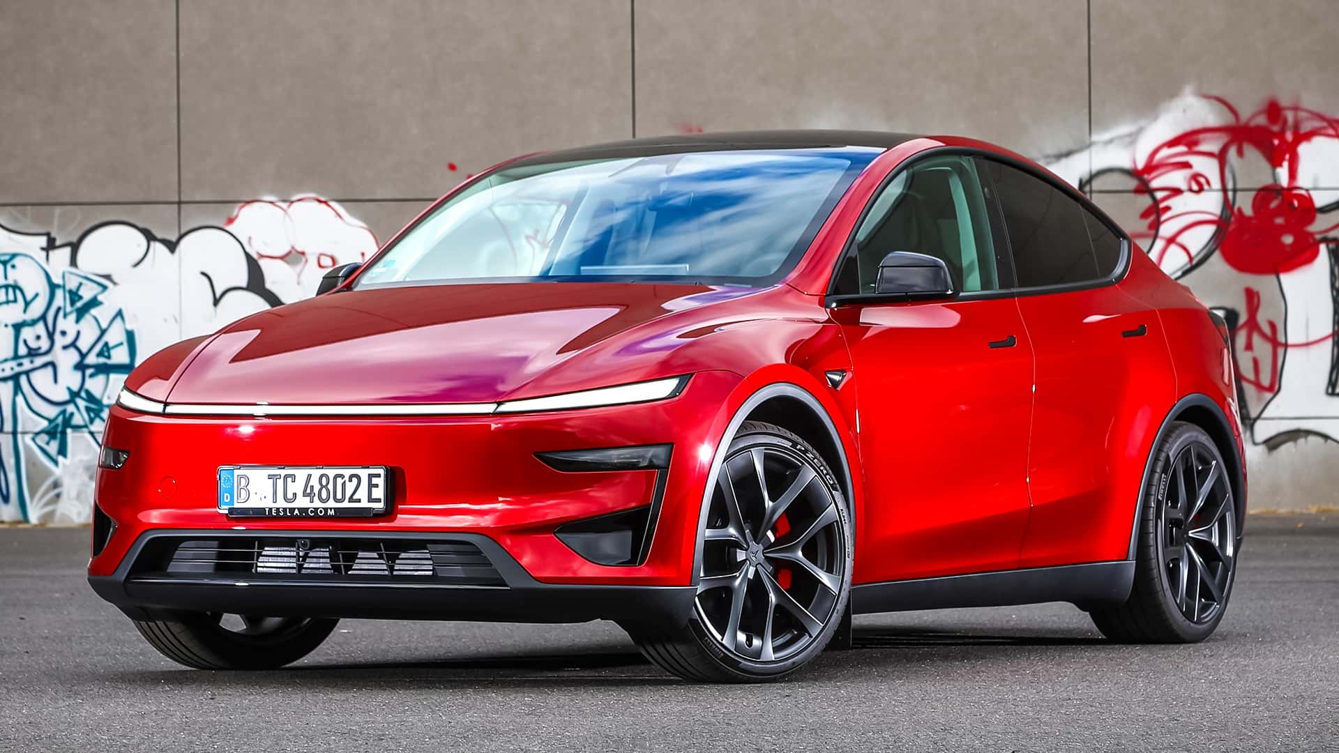 Tesla elbil parkeret foran graffiti