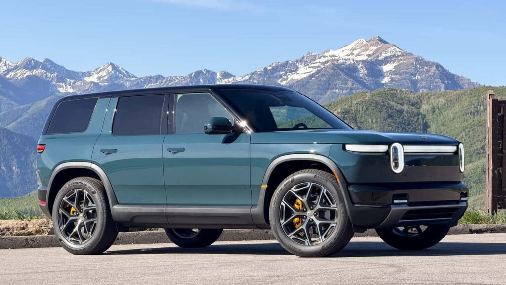 Rivian SUV under bjerge i solskin