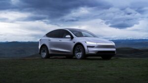 Tesla elbil i naturlandskab ved solnedgang