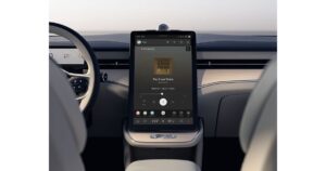 Infotainmentskærm i elektrisk bils interiør med musikafspiller.
