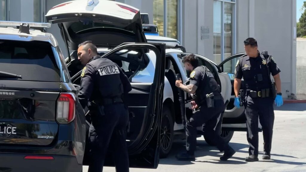 Politifolk ved Jaguar bil med åbne døre