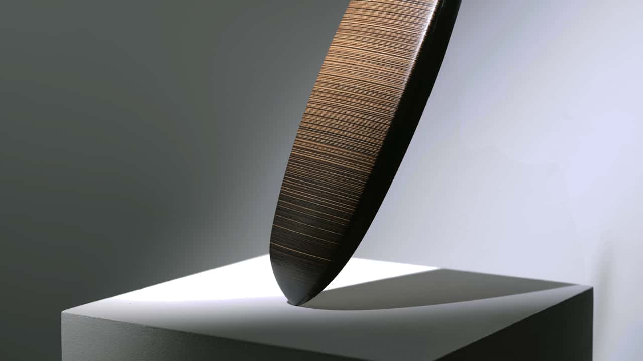 Moderne kunstskulptur belyst på piedestal