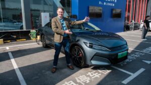 BYD elektrisk sedan under opladning med person ved siden af