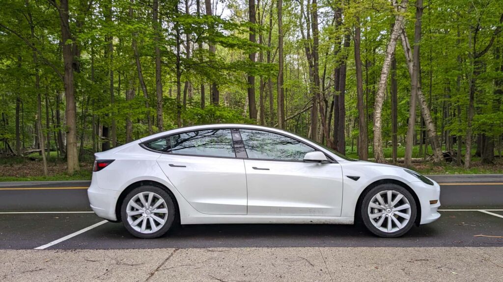 Tesla Model 3 parkeret foran en skov