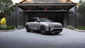 Elektrisk SUV parkeret foran moderne bygning