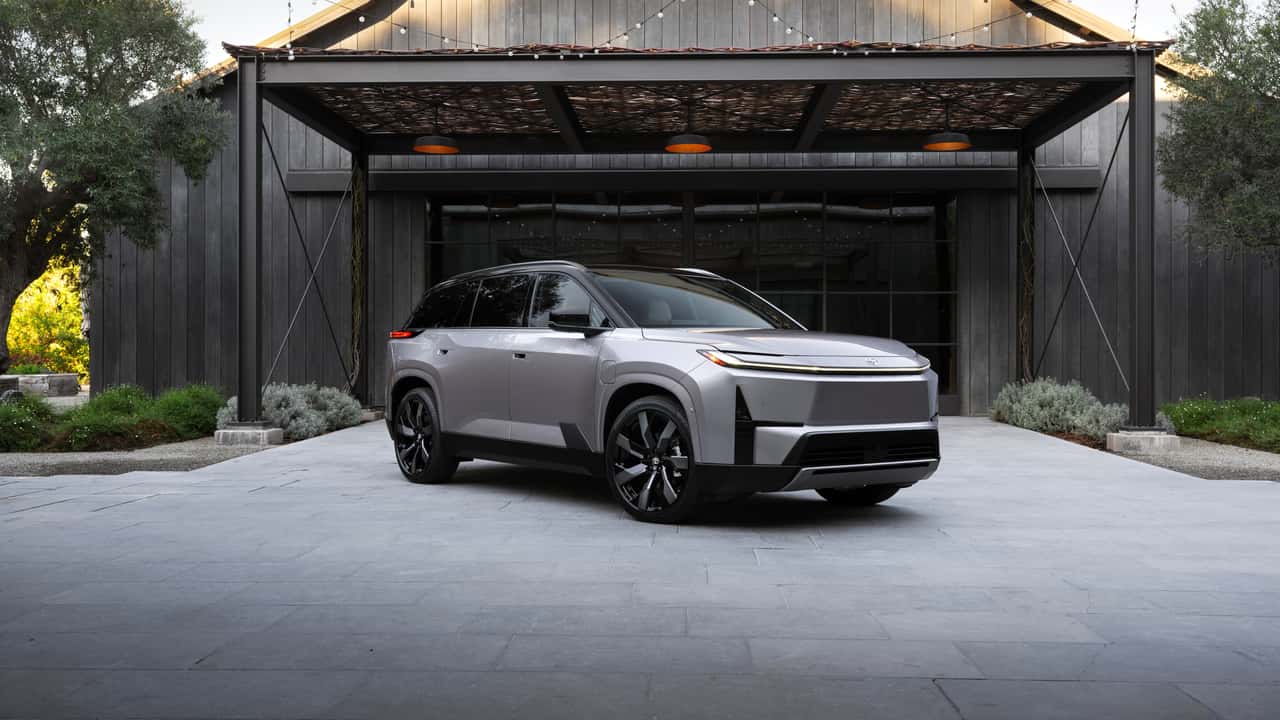 Elektrisk SUV parkeret foran moderne bygning