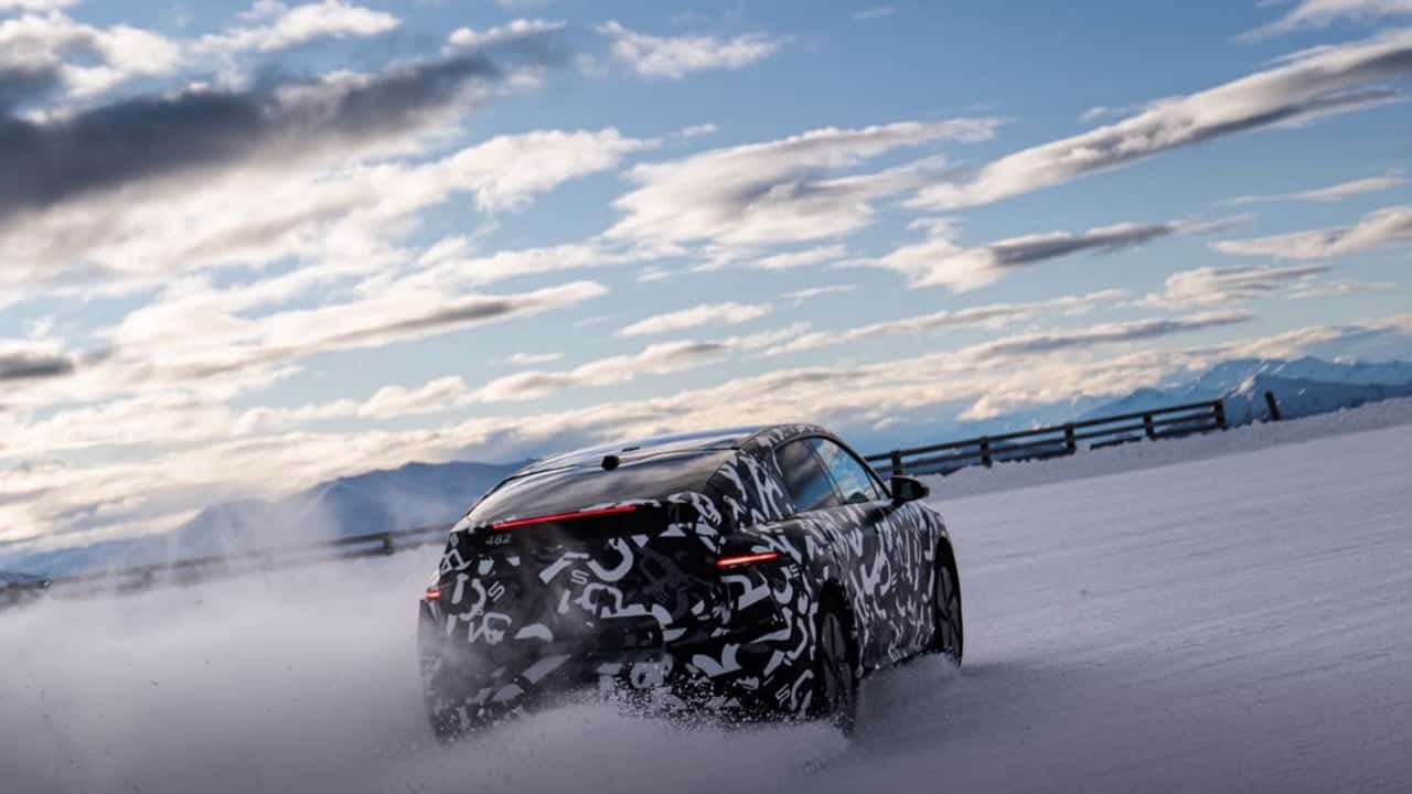 Elektrisk SUV i camouflagedragt kører på snedækket vej