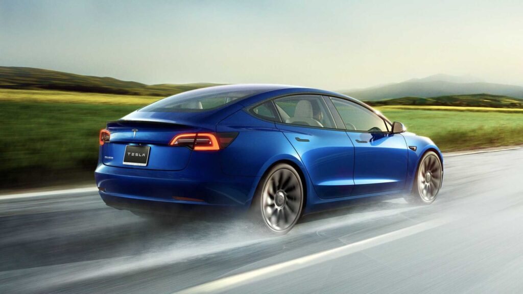Blå Tesla Model 3 kører på landevej