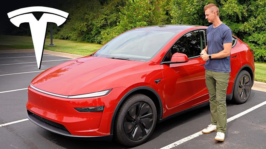 Rød Tesla SUV parkeret udendørs med mand ved siden af