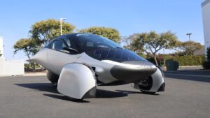Futuristisk trehjulet elbil parkeret udendørs