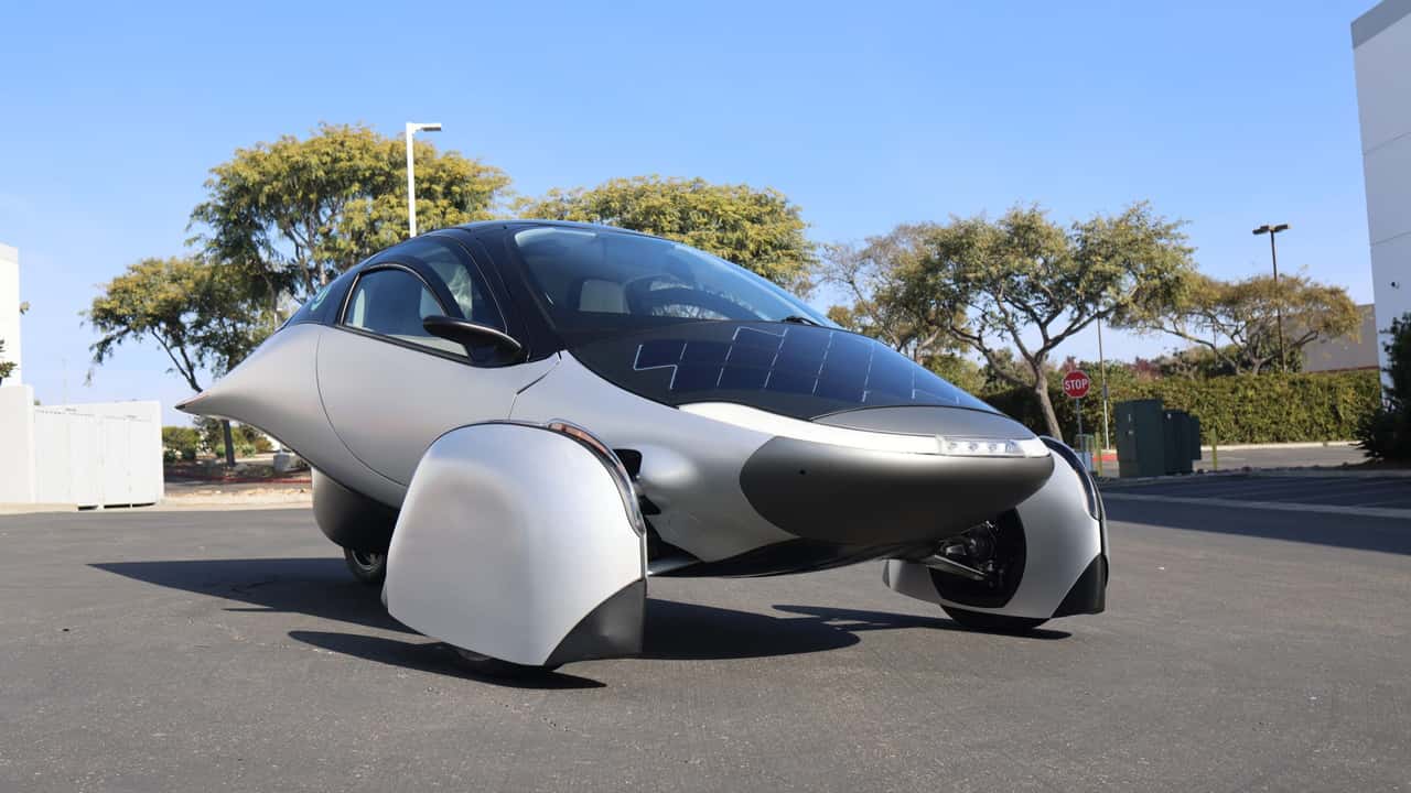 Futuristisk trehjulet elbil parkeret udendørs