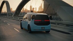 Waymo selvkørende bil på bybro ved solnedgang