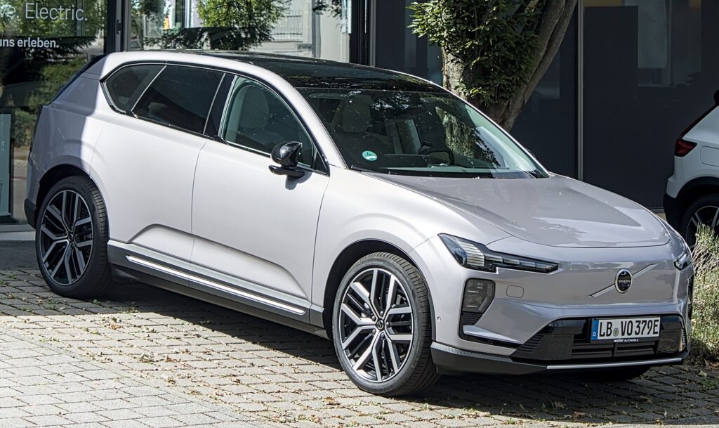 Sølvgrå Volvo EX60 parkeret foran en forhandler