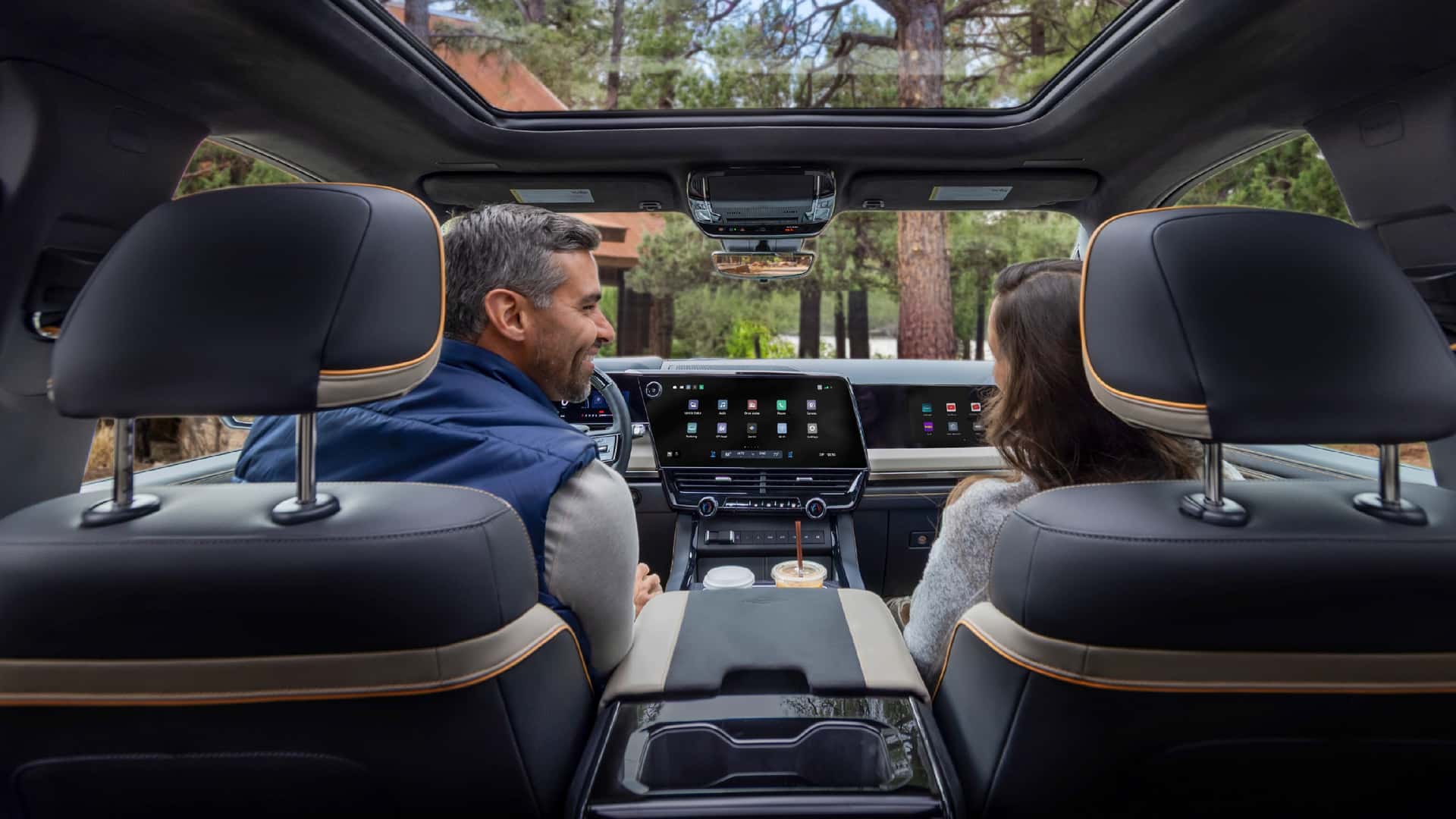 Indvendig i en elektrisk SUV, to personer kigger på dashboard