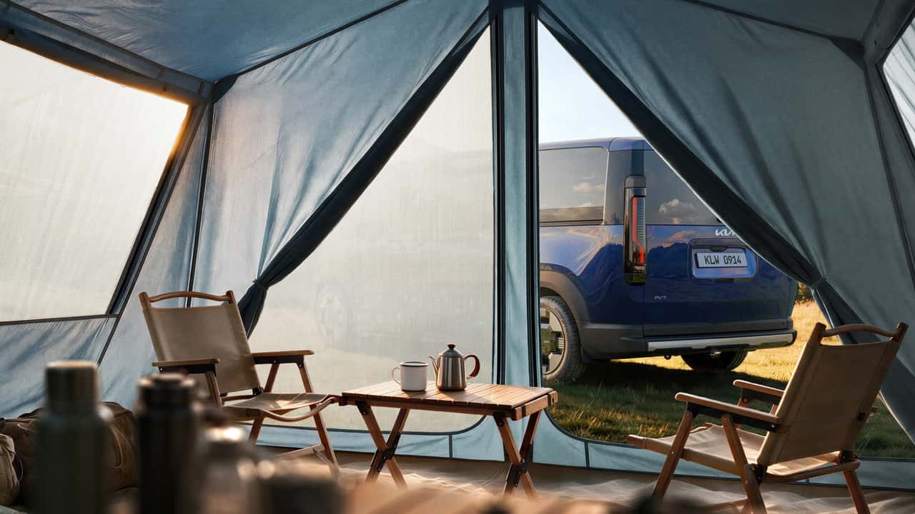 Kia EV parkeret ved campingområde set fra telt