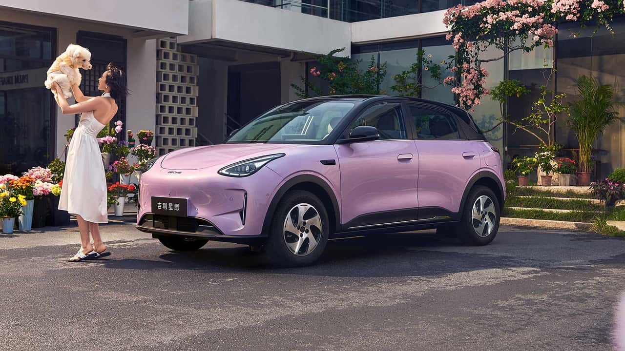 Elektrisk SUV foran hus med kvinde og hund