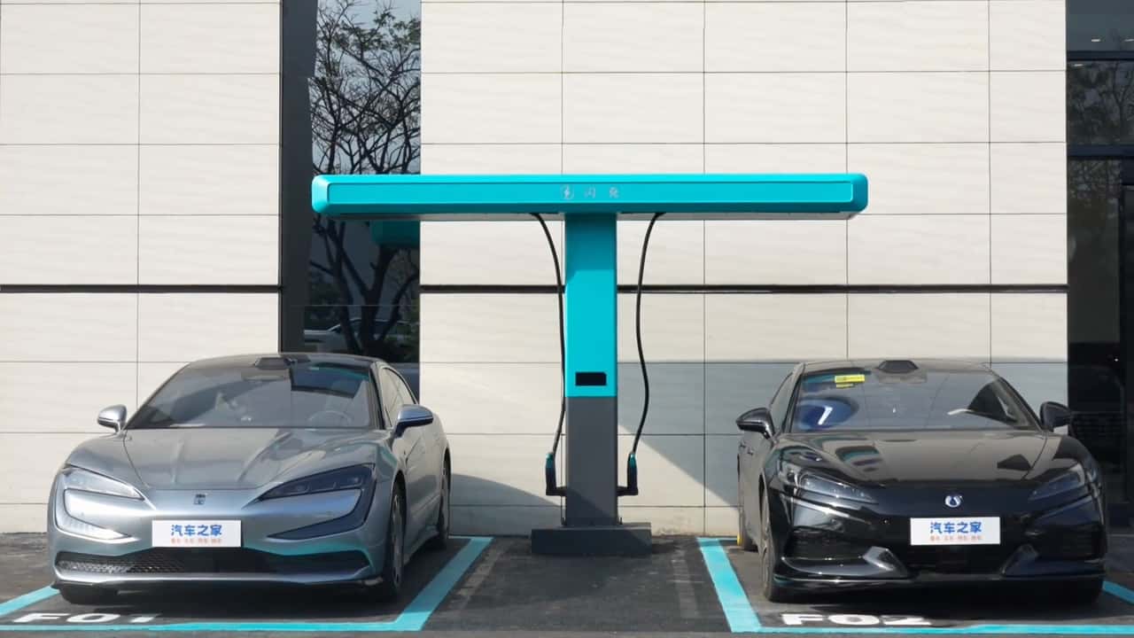 To elektriske sedaner oplader ved station