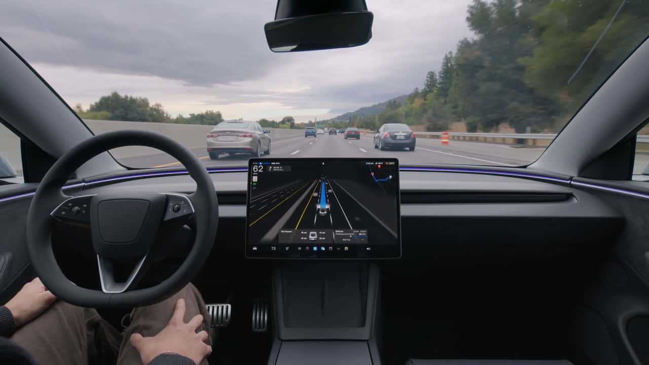 Interiør af bil med autopilot aktiveret på motorvej