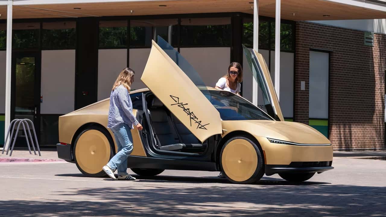 Gul elektrisk sedan med opladningsdøre åbne foran bygning