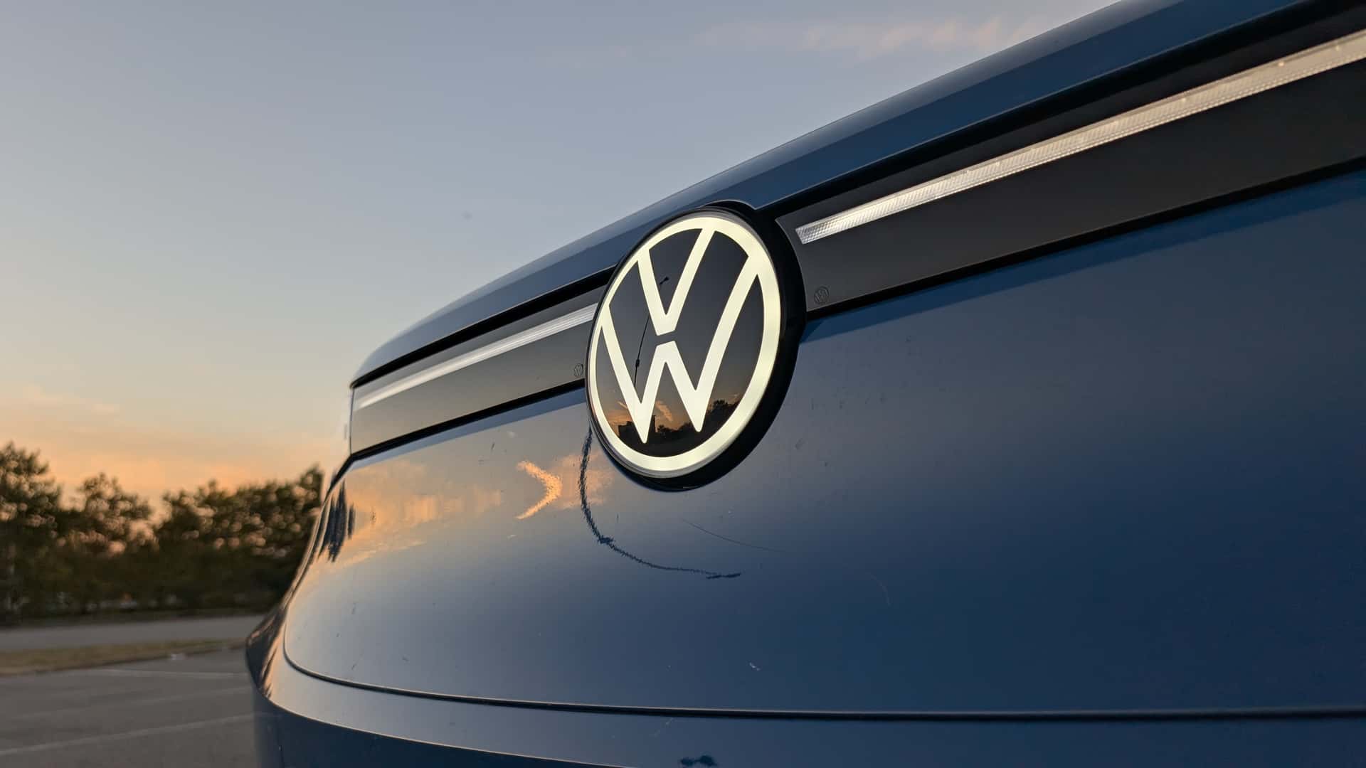 Volkswagen logo på blå bil i solnedgang
