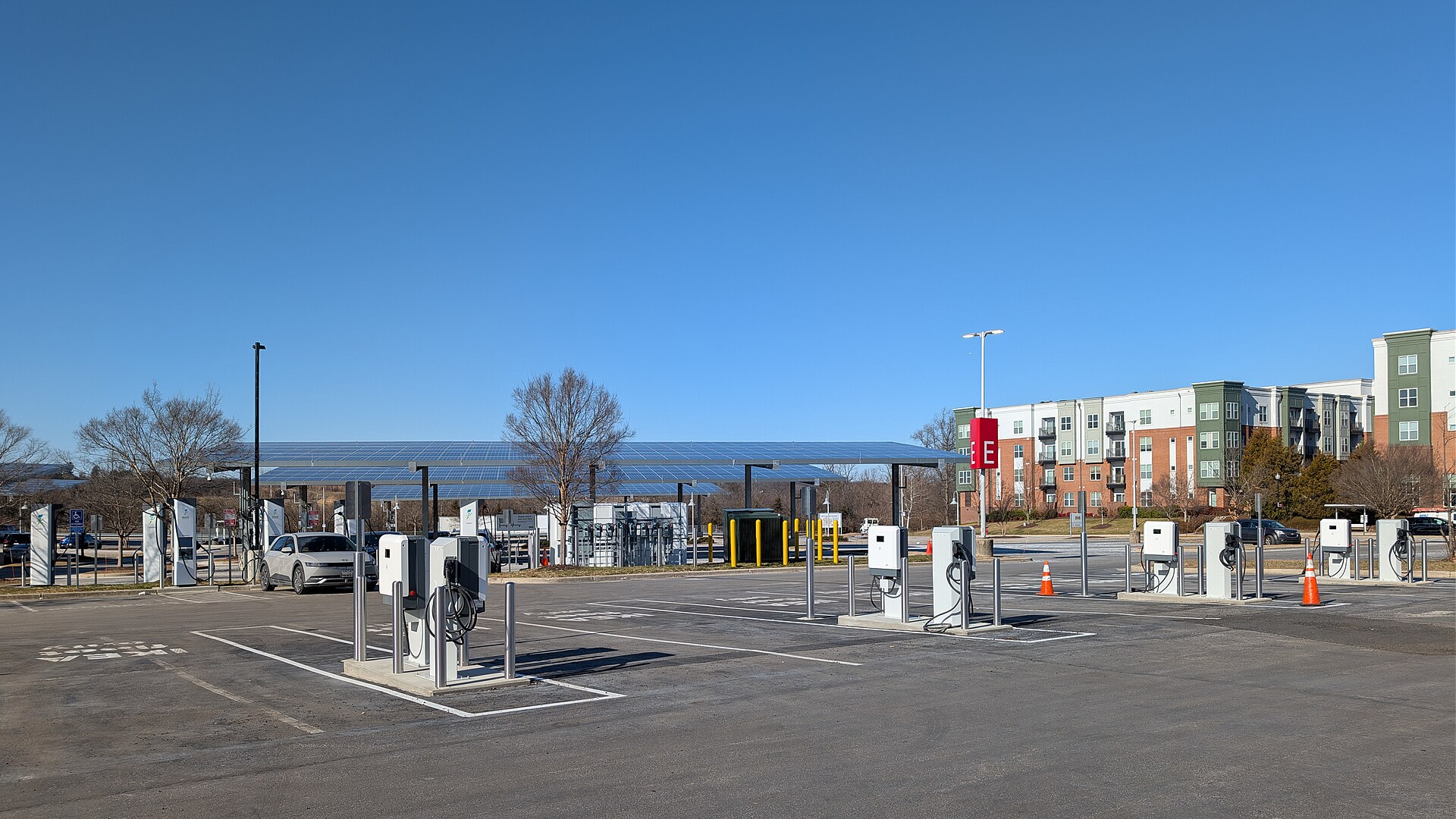 Række af DC-lynladere på en parkeringsplads under en solcelleoverdækning