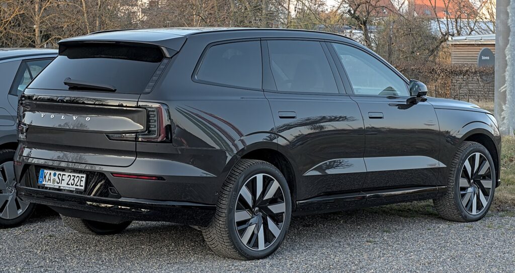 Sort Volvo EX90 set skråt bagfra på en parkeringsplads