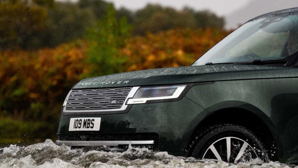 Range Rover model krydser vandløb under regnvejr