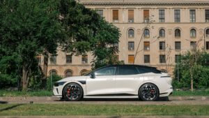Hvid elektrisk bil parkeret foran bygning