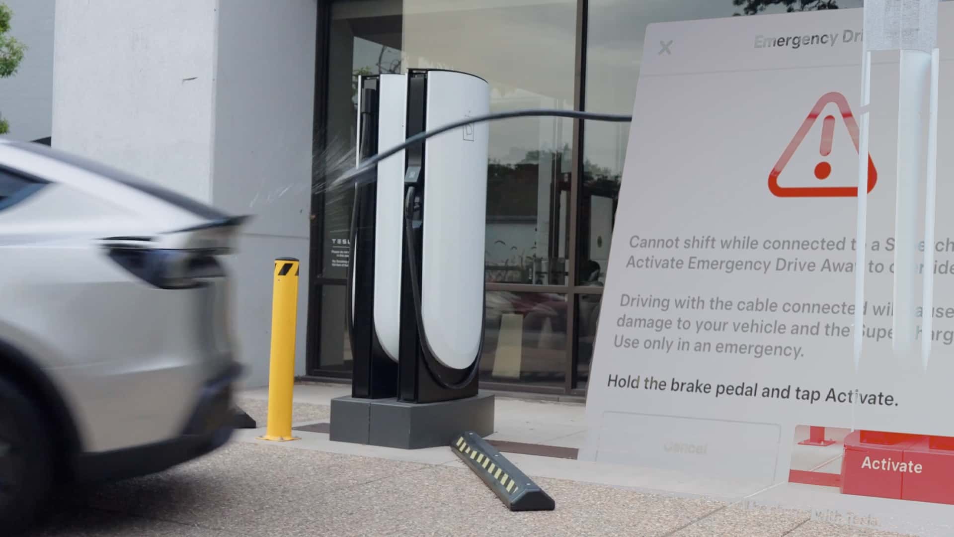 Tesla kører fra Supercharger-station med kabel tilkoblet
