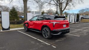 Rød Chevrolet elektrisk SUV parkeret ved Tesla ladestation